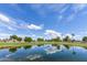 Scenic golf course view featuring a tranquil pond reflecting blue skies and fluffy white clouds at 1642 E Palm Beach Dr, Chandler, AZ 85249