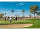 Golfers putting on a meticulously kept green, showcasing a vibrant and inviting course with desert landscaping at 1642 E Palm Beach Dr, Chandler, AZ 85249
