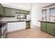 Bright kitchen featuring green and white cabinetry, stainless steel appliances, and wood flooring at 1642 E Palm Beach Dr, Chandler, AZ 85249