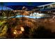 Resort-style pool area with a shaded lounge area and lush landscaping at night at 1642 E Palm Beach Dr, Chandler, AZ 85249