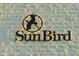 Close-up of the SunBird sign, beautifully illuminated on the building's textured brick facade at 1642 E Palm Beach Dr, Chandler, AZ 85249