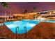 Community pool at night featuring an illuminated pool and surrounding buildings at 1642 E Palm Beach Dr, Chandler, AZ 85249