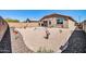 Spacious backyard with gravel landscaping, a covered patio, and tastefully decorated with artistic metal and ceramic lawn ornaments at 16593 W Alameda Rd, Surprise, AZ 85387