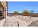 The backyard is spacious with bricked and gravel areas, and is decorated with metal and ceramic lawn ornaments at 16593 W Alameda Rd, Surprise, AZ 85387