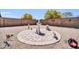 An artistic backyard with metal lawn ornaments surrounding a central decorative stone feature, fully landscaped with gravel at 16593 W Alameda Rd, Surprise, AZ 85387