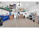 Garage with epoxy flooring, shelving, storage cabinets, refrigerator, overhead storage racks, and an automatic door at 16593 W Alameda Rd, Surprise, AZ 85387