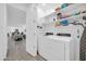 Well-organized laundry room with modern washer and dryer, shelving, and ample storage space at 16593 W Alameda Rd, Surprise, AZ 85387