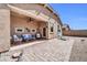 Covered patio with outdoor seating, ceiling fan, and view of a large backyard with rock and brick landscaping at 16593 W Alameda Rd, Surprise, AZ 85387