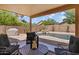 Outdoor living space with a covered patio, BBQ area, a waterfall, and lush landscaping at 16648 W Adams St, Goodyear, AZ 85338