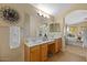 Bright bathroom features dual sinks, vanity and view into the main bedroom at 16648 W Adams St, Goodyear, AZ 85338