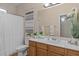 Bright bathroom features large mirror and a shower with curtain at 16648 W Adams St, Goodyear, AZ 85338