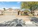 Charming single-story home with a three-car garage, desert landscaping, and mature shade trees at 16648 W Adams St, Goodyear, AZ 85338