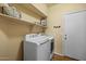 Laundry room with washer, dryer, storage shelves, and clean, organized functionality at 16648 W Adams St, Goodyear, AZ 85338