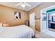 Comfortable bedroom with ceiling fan leads to ensuite bathroom; neutral walls and artistic décor at 17017 N 12Th St # 2117, Phoenix, AZ 85022