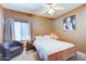 Cozy bedroom featuring a ceiling fan, plush chair, and warm carpeting, complemented by an artistic painting at 17017 N 12Th St # 2117, Phoenix, AZ 85022