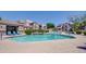 Beautiful pool area with mature landscaping, lounge chairs, and residential buildings in the background at 17017 N 12Th St # 2117, Phoenix, AZ 85022