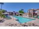 Community pool area with lounge seating, palm trees, and residential buildings in the background on a sunny day at 17017 N 12Th St # 2117, Phoenix, AZ 85022
