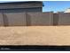 Large, empty backyard enclosed by a concrete block wall, offering a blank canvas for landscaping at 17677 W Odeum Ln, Goodyear, AZ 85338