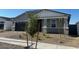 Single-story home with a gray exterior, black garage door, and a small, newly landscaped front yard at 17677 W Odeum Ln, Goodyear, AZ 85338