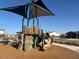 Community playground equipment features slide and climbing structure for to enjoy at 17677 W Odeum Ln, Goodyear, AZ 85338