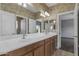 Bathroom features a double sink vanity, mirrors, and a view of bedroom at 18330 W Woodrow Ln, Surprise, AZ 85388