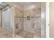 Spacious shower with built-in bench, shower head, and decorative wall and floor tiling at 18330 W Woodrow Ln, Surprise, AZ 85388