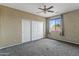 Bedroom features a sliding door closet, ceiling fan, and plenty of natural light at 18330 W Woodrow Ln, Surprise, AZ 85388