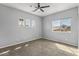 Carpeted bedroom with ceiling fan, three windows, and light gray paint at 18330 W Woodrow Ln, Surprise, AZ 85388