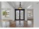 Elegant foyer showcasing tile flooring, a decorative chandelier, and a beautiful front door at 18330 W Woodrow Ln, Surprise, AZ 85388