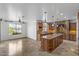 Open kitchen features granite counters, large center island, stone accent wall, and view of the outdoor pool at 18330 W Woodrow Ln, Surprise, AZ 85388