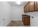 Functional laundry room features plenty of cabinet storage, sink and tile floors at 18330 W Woodrow Ln, Surprise, AZ 85388