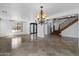 Open concept living area featuring tile floors, a chandelier, and an elegant staircase at 18330 W Woodrow Ln, Surprise, AZ 85388