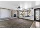 Spacious living room with decorative fireplace, carpet, and windows overlooking the backyard pool at 18330 W Woodrow Ln, Surprise, AZ 85388