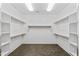Spacious walk-in closet with ample shelving, wooden rods and neutral color palette at 18330 W Woodrow Ln, Surprise, AZ 85388