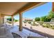 Backyard view from the covered patio, featuring desert landscaping with gravel and mature trees at 19472 N Marble Canyon Ct, Surprise, AZ 85374