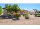 Well-maintained backyard with desert landscaping and a cozy patio area with chairs at 19472 N Marble Canyon Ct, Surprise, AZ 85374