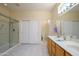 Bright bathroom featuring double sinks, a glass shower enclosure, and tile flooring at 19472 N Marble Canyon Ct, Surprise, AZ 85374