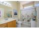 Bright bathroom with a single sink vanity, neutral tones, and a decorative shower curtain at 19472 N Marble Canyon Ct, Surprise, AZ 85374