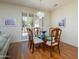 Formal dining area featuring wood floors, seating for six, elegant light fixture and sliding door at 19472 N Marble Canyon Ct, Surprise, AZ 85374