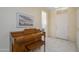 Inviting tiled foyer with an elegant piano, decorative wall art, and a bright white front door at 19472 N Marble Canyon Ct, Surprise, AZ 85374