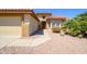 Charming home with desert landscaping, featuring a terracotta roof, two-car garage and walkway to the front door at 19472 N Marble Canyon Ct, Surprise, AZ 85374