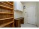 Hallway with desk space, wood shelving and view of the back door at 19472 N Marble Canyon Ct, Surprise, AZ 85374