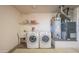 Utility room featuring a washer, dryer, sink, shelving, and water heater at 19472 N Marble Canyon Ct, Surprise, AZ 85374