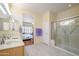Open bathroom featuring double sinks, a glass shower enclosure, and an adjacent bedroom at 19472 N Marble Canyon Ct, Surprise, AZ 85374
