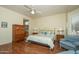 Spacious main bedroom offering hardwood floors, a ceiling fan, and access to the main bathroom at 19472 N Marble Canyon Ct, Surprise, AZ 85374