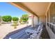 Covered patio featuring lounge chairs overlooking a desert landscape with gravel and mature trees at 19472 N Marble Canyon Ct, Surprise, AZ 85374