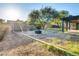 Spacious backyard area including mature trees and a patio area with a shade cover and trampoline at 19604 N 13Th Ave, Phoenix, AZ 85027