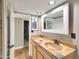 Neutral-toned bathroom with patterned stone countertops, decorative mirrors, and wood cabinets at 19604 N 13Th Ave, Phoenix, AZ 85027