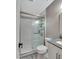 Nicely tiled and updated bathroom including a shower with a glass enclosure, white cabinets, and grey stone countertops at 19604 N 13Th Ave, Phoenix, AZ 85027