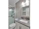 Renovated bathroom featuring modern vanity, grey countertops, framed mirror, and glass enclosed shower with white subway tile at 19604 N 13Th Ave, Phoenix, AZ 85027